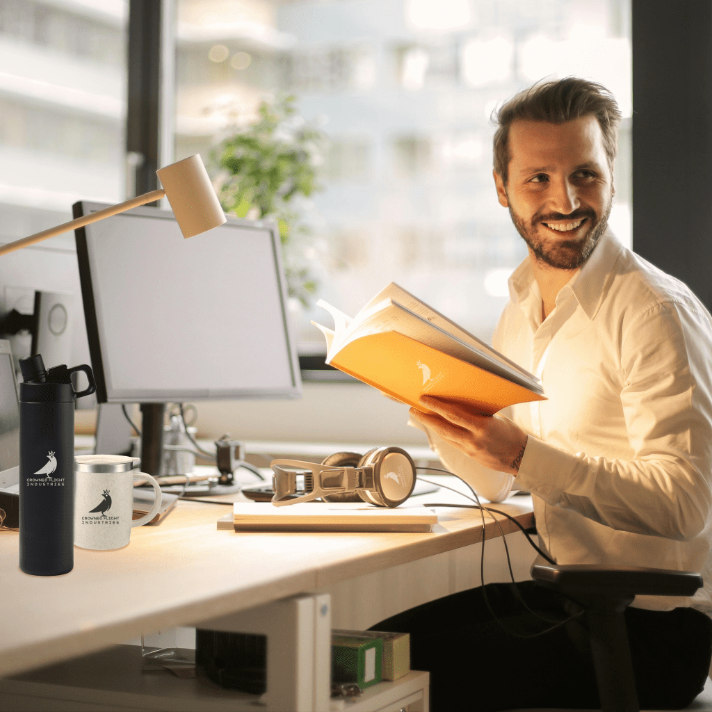bearded man sitting at office desk with logoed company products
