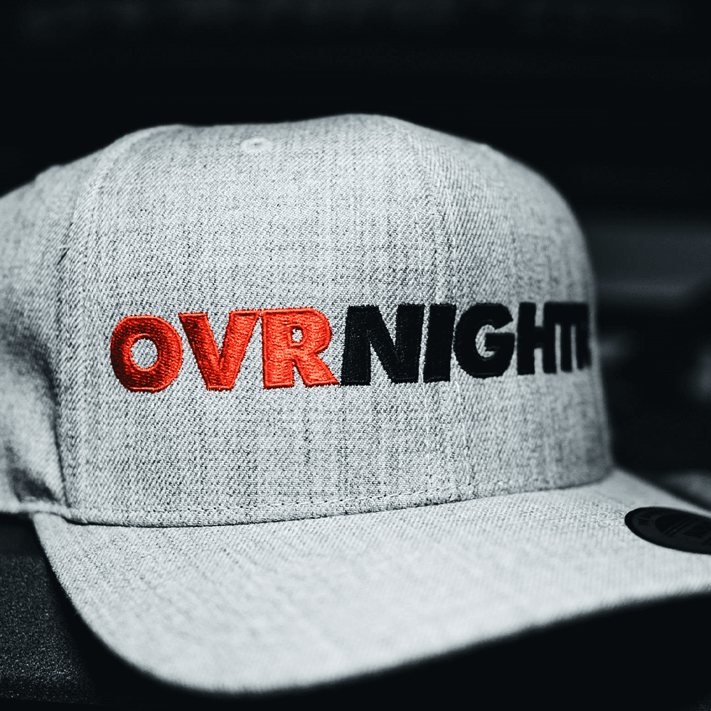 Cap with 'Ovrnight' embroidered in black and red